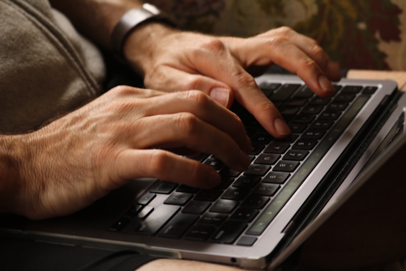 Hands typing an email on a laptop keyboard